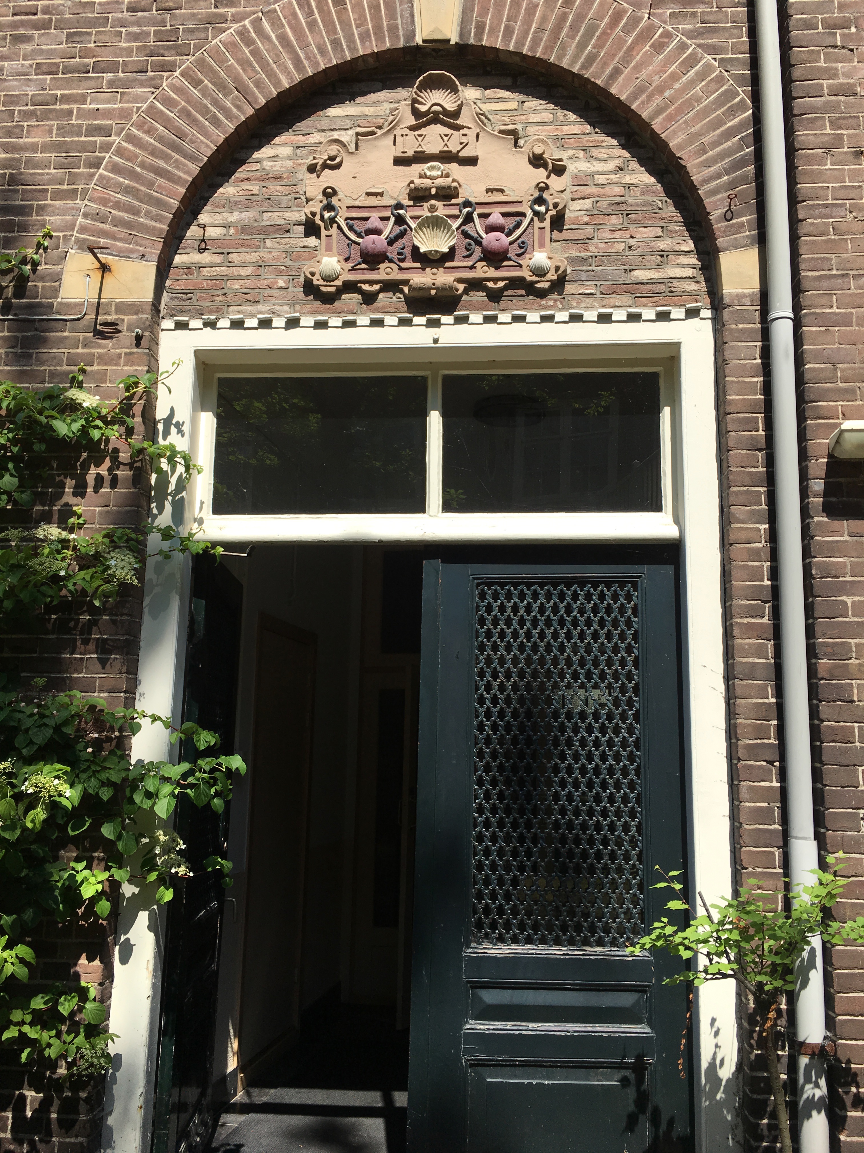 deur naar de tuin van het Rosenstock Huessy Huis, met pelgrimsembleem 
