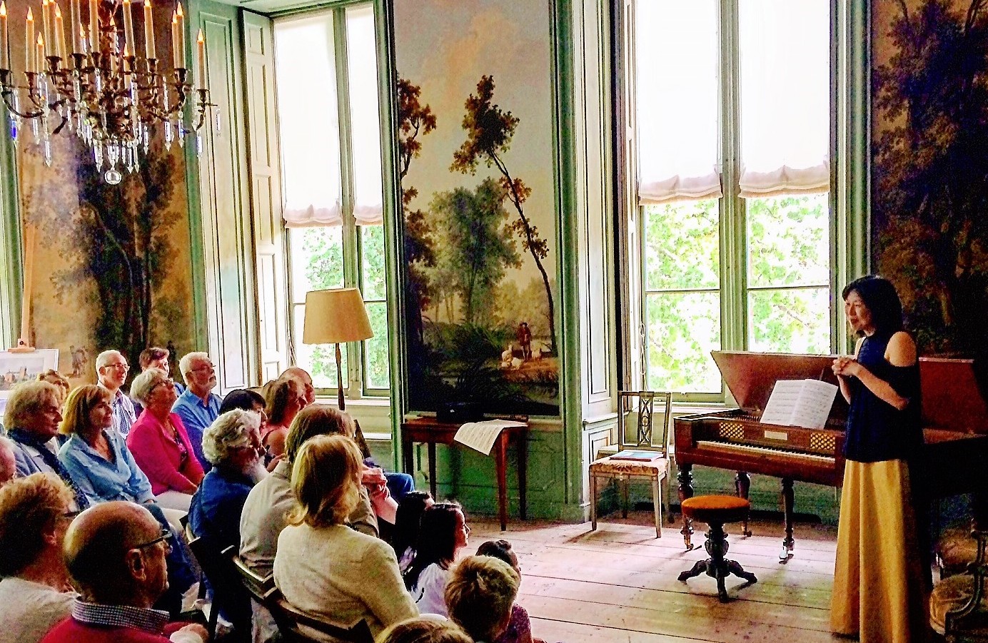 Kaoru Iwamura licht haar programma toe voor haar publiek in de tuinkamer van Kasteel Loenersloot